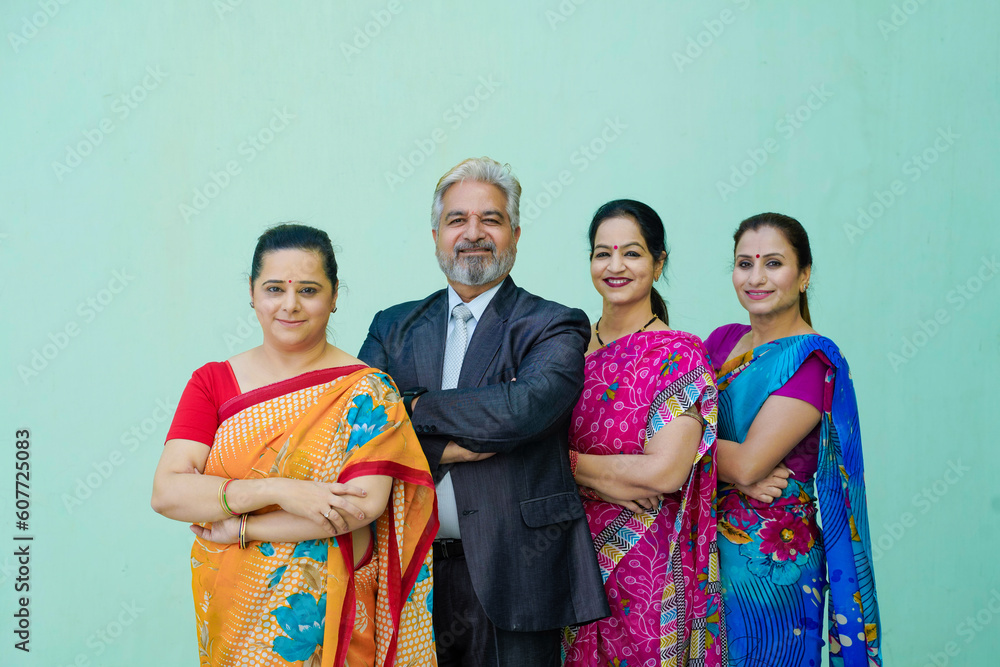 Senior businessman standing with women group.