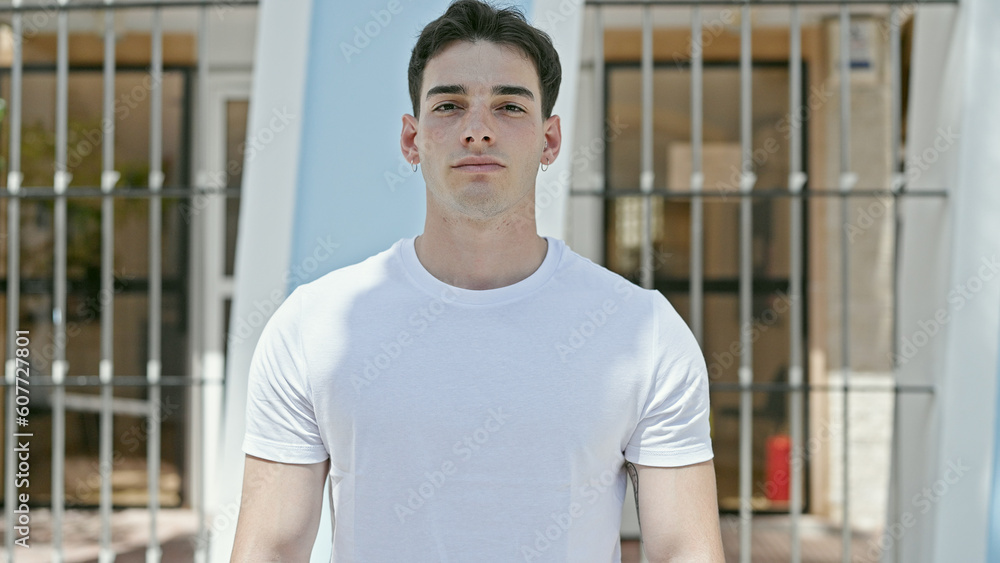 Young hispanic man standing with serious expression at street Young hispanic man standing with serious expression at street