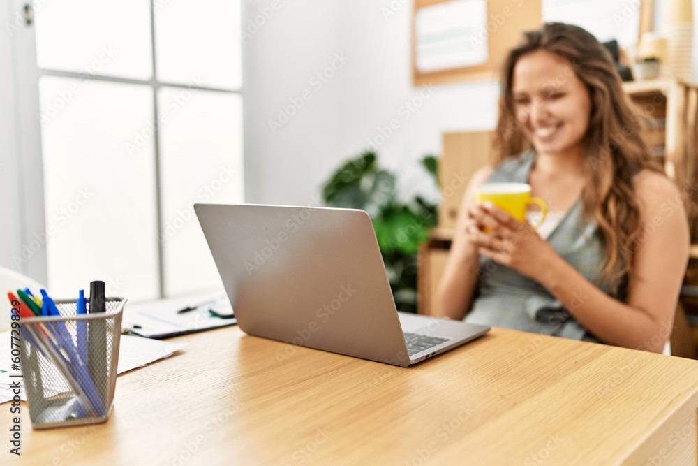 Young beautiful hispanic woman business worker using laptop drinking coffee at office Young beautiful hispanic woman business worker using laptop drinking coffee at office
