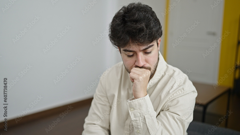 Fototapeta premium Young hispanic man stressed sitting on sofa at home