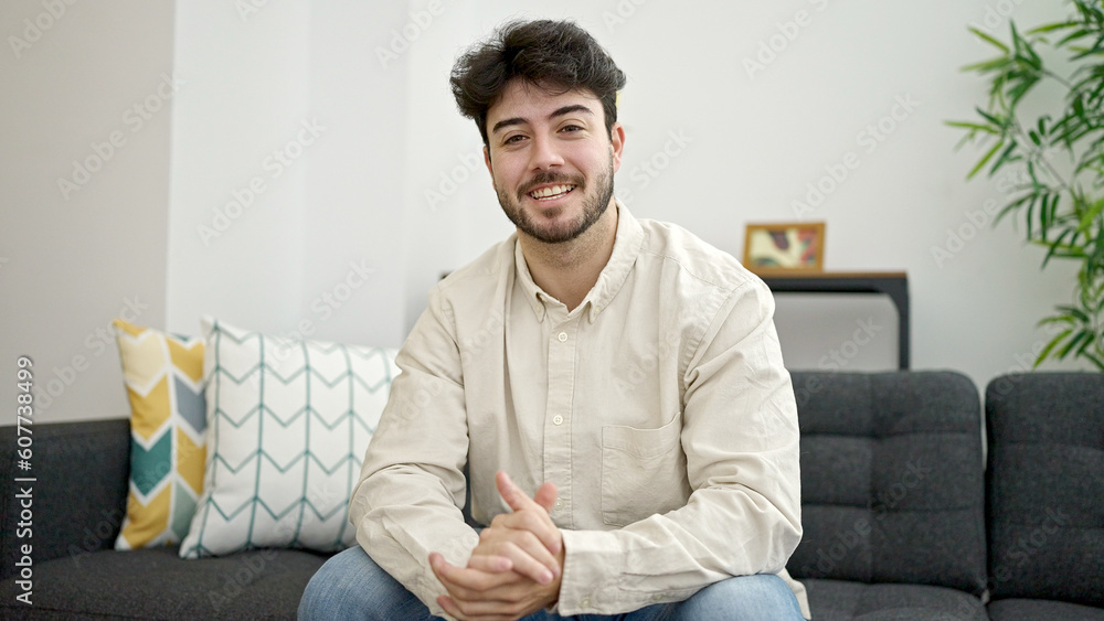Young hispanic man smiling confident sitting on sofa at home Young hispanic man smiling confident sitting on sofa at home