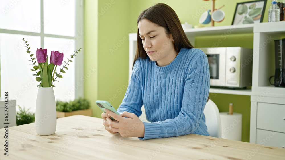 Young caucasian woman using smartphone sitting on table at dinning room Young caucasian woman using smartphone sitting on table at dinning room