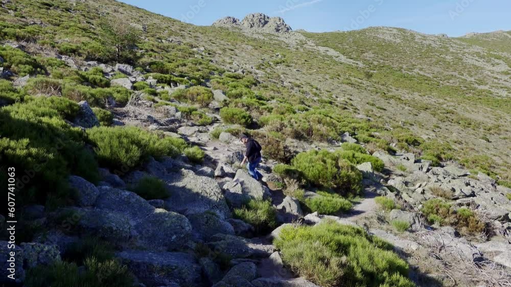 Man hiking up the slope of a mountain range in central Spain, Guadarrama.