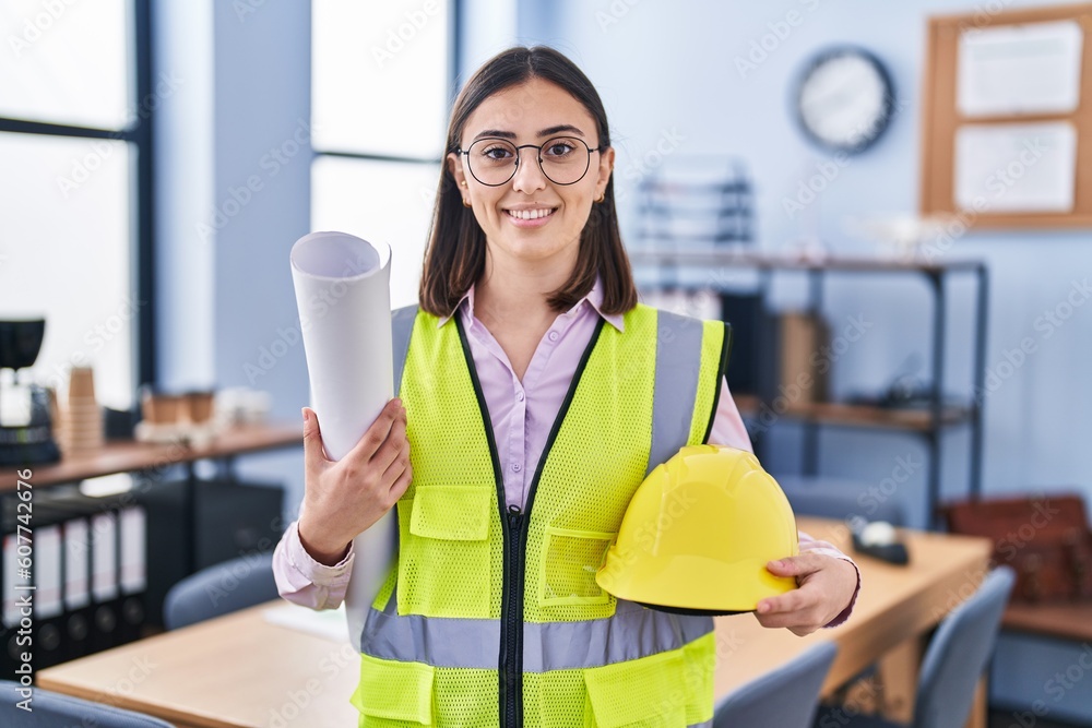 Hispanic girl architect holding build project blueprints smiling with a happy and cool smile on face. showing teeth. Hispanic girl architect holding build project blueprints smiling with a happy and cool smile on face. showing teeth.