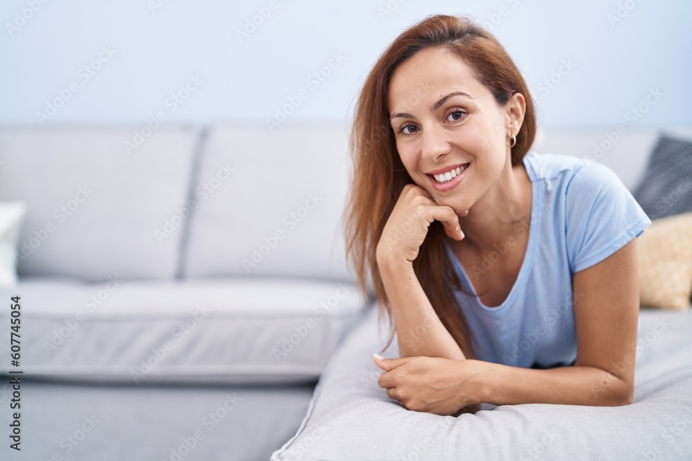 Young woman smiling confident lying on sofa at home Young woman smiling confident lying on sofa at home