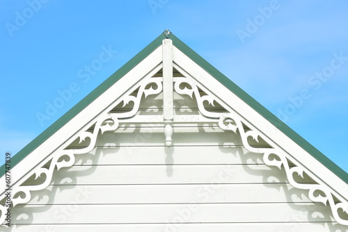 Gable end with weatherboard and ornamental fascia under green metal roof.