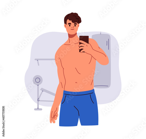 Man takes selfie with mobile phone in gym mirror. Young guy with naked torso,...
