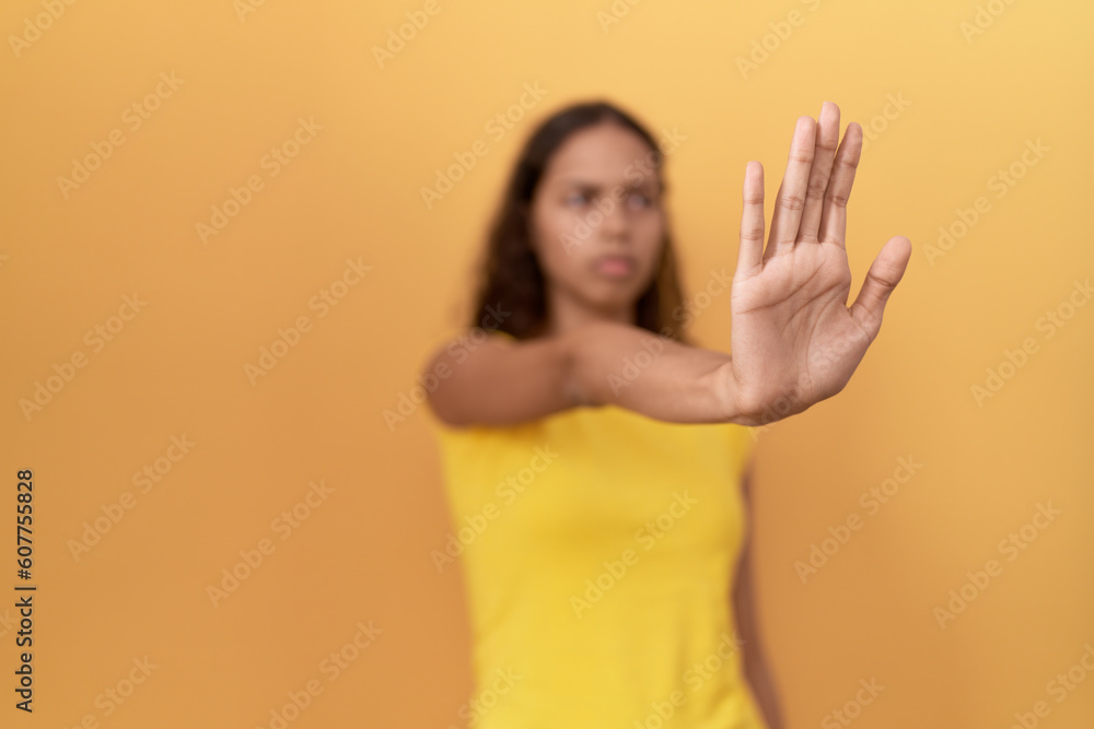 Young african american woman doing stop gesture with hand over isolated yellow background Young african american woman doing stop gesture with hand over isolated yellow background