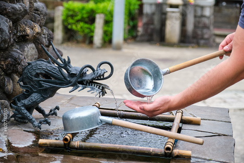 Person performing ablution, ceremonial purification rite known as temizu or chozu in Kyoto, Japan.