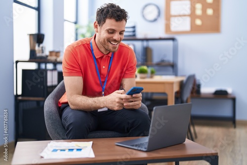Young hispanic man business worker using laptop and smartphone working at office