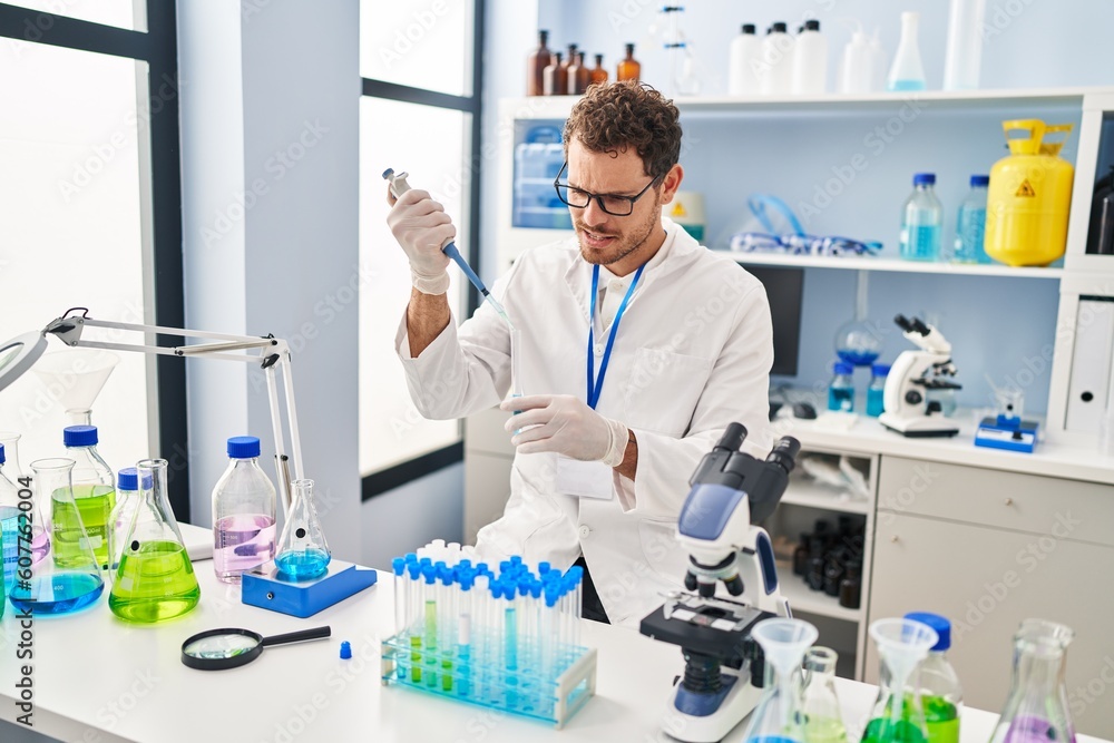 © Krakenimages.com - Young hispanic man scientist pouring liquid on test tube at laboratory © Krakenimages.com - Young hispanic man scientist pouring liquid on test tube at laboratory