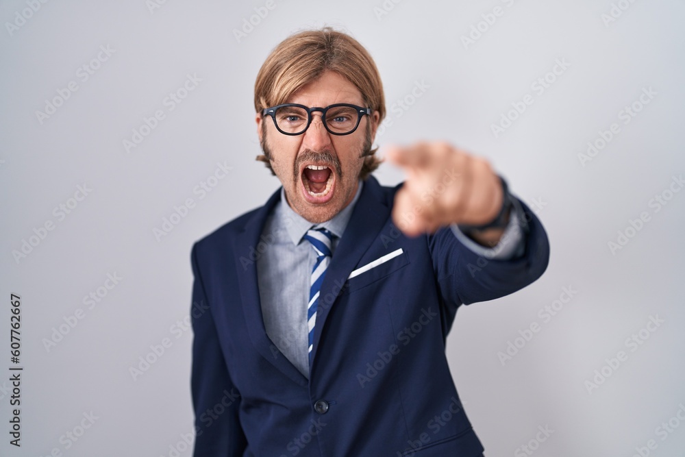 Caucasian man with mustache wearing business clothes pointing displeased and frustrated to the camera, angry and furious with you Caucasian man with mustache wearing business clothes pointing displeased and frustrated to the camera, angry and furious with you