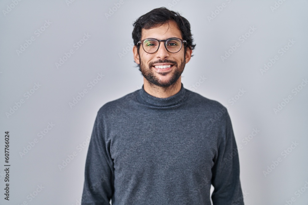 Handsome latin man standing over isolated background with a happy and cool smile on face. lucky person. Handsome latin man standing over isolated background with a happy and cool smile on face. lucky person.