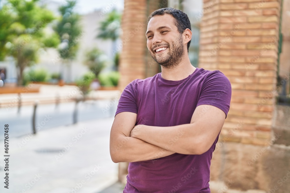 Fototapeta premium Young man smiling confident standing with arms crossed gesture at park