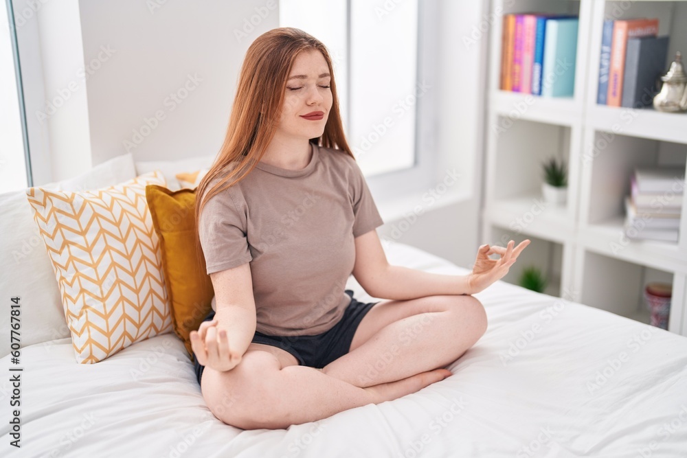 Young redhead woman doing yoga exercise sitting on bed at bedroom Young redhead woman doing yoga exercise sitting on bed at bedroom
