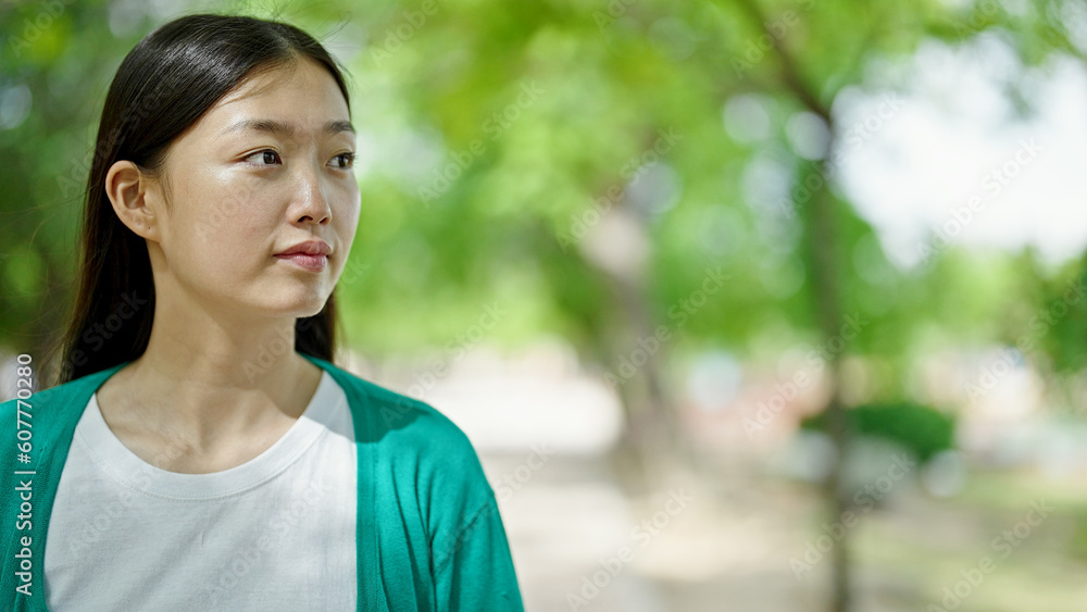 Young chinese woman looking to the side with serious expression at park Young chinese woman looking to the side with serious expression at park