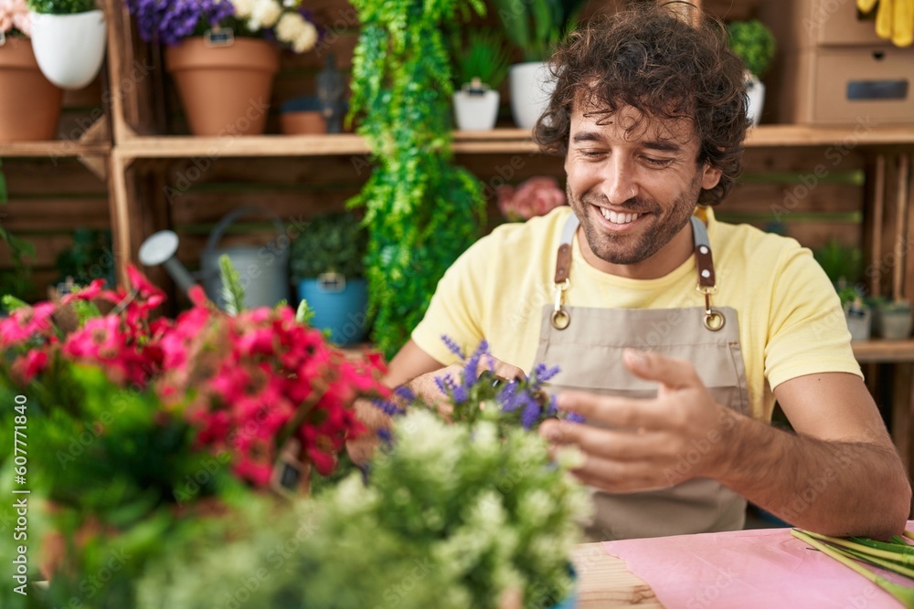 Young hispanic man florist smiling confident touching plant at flower shop Young hispanic man florist smiling confident touching plant at flower shop