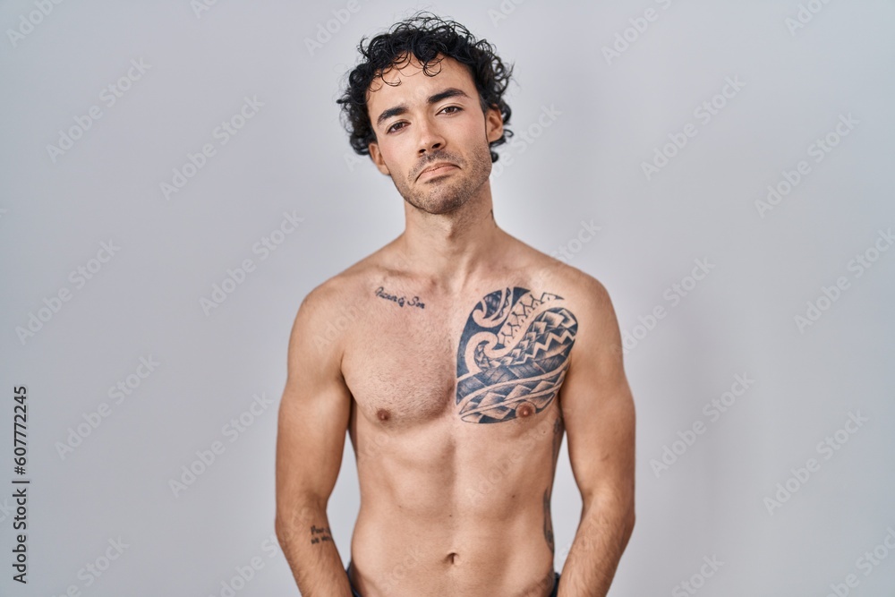Fototapeta premium Hispanic man standing shirtless depressed and worry for distress, crying angry and afraid. sad expression.