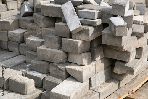 Old square paving slabs laid out in vertical rows. Processing of materials, recycling and storage of bricks.