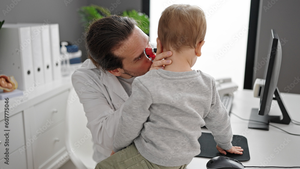 Father and son doctor examining ear at clinic Father and son doctor examining ear at clinic