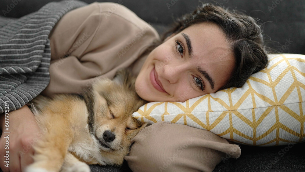 Young hispanic woman with dog smiling confident lying on sofa at home Young hispanic woman with dog smiling confident lying on sofa at home