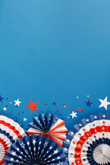 Concept of a July 4th celebration event. Top view flat lay of patriotic folding fans, blue, red, white stars on blue background with empty space for text or advert