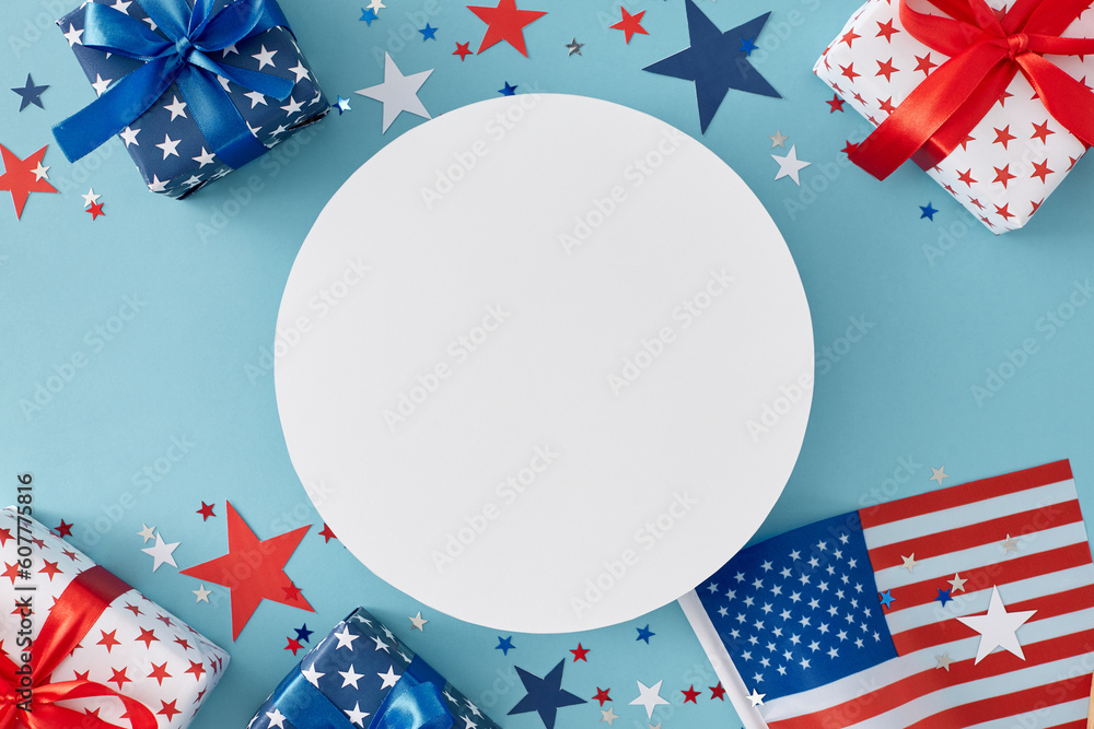 Obraz premium Fourth of July concept. Top view flat lay of gift boxes in patriotic colors, national flag, star-shaped confetti on light blue background with empty circle for text or ads