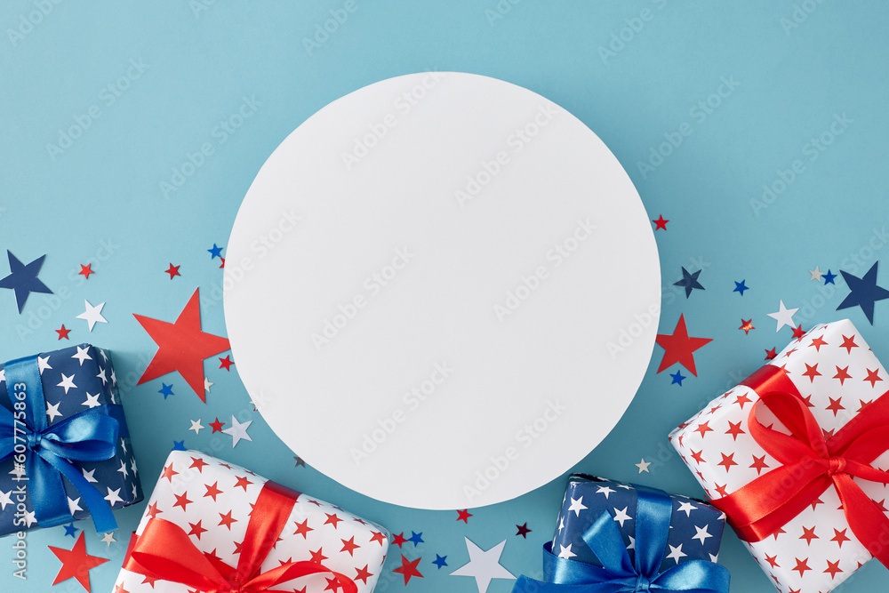 Obraz premium 4th of July gift theme concept. Top view flat lay of gift boxes in patriotic colors, blue, red, white stars on pastel blue background with blank circle for text or advertisement