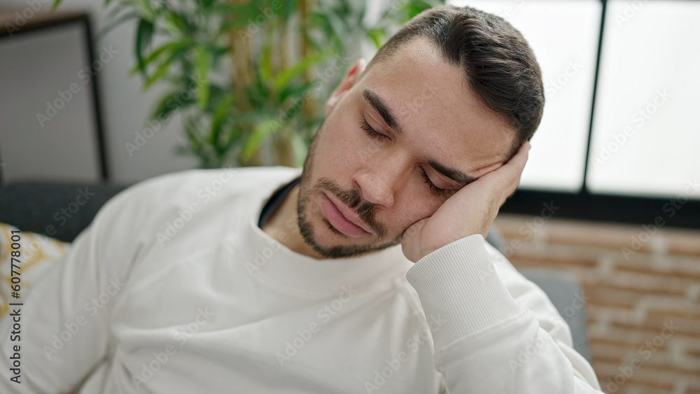 Young hispanic man sitting on sofa sleeping at home Young hispanic man sitting on sofa sleeping at home