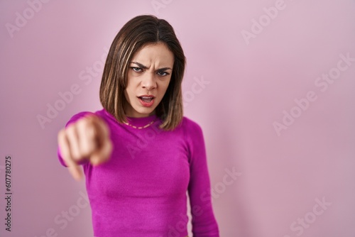 Hispanic woman standing over pink background pointing displeased and frustrated to the camera  angry and furious with you