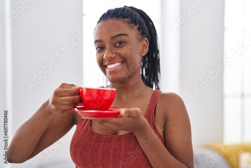 African american woman smiling confident drinking coffee at home