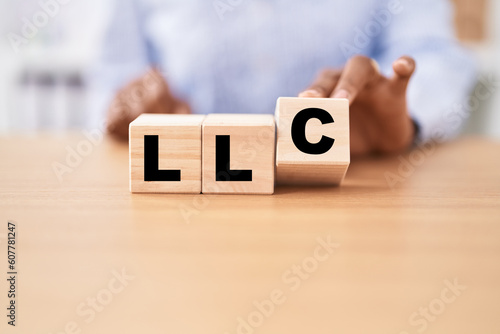 Black woman holding cubes with llc word on the table photo