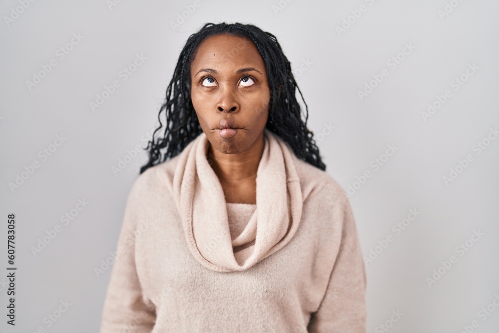 African woman standing over white background making fish face with lips, crazy and comical gesture. funny expression. African woman standing over white background making fish face with lips, crazy and comical gesture. funny expression.