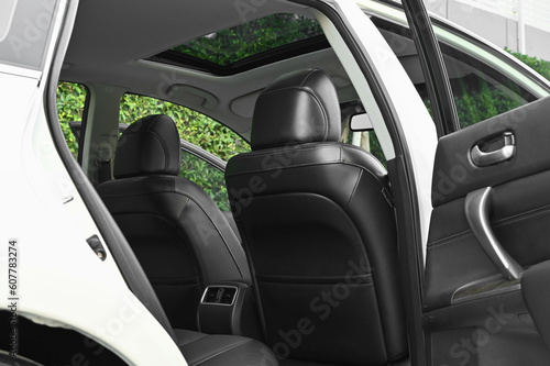 The rear passenger seat is wide and clean. Leather interior, side view, solar sunroof, buttons, Nappa leather, beige,black © chatchai