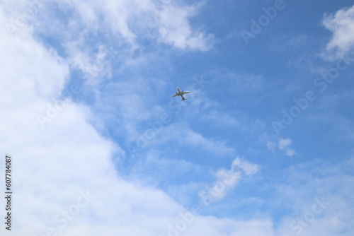 passenger airplane is flying in the blue sky with white clouds
