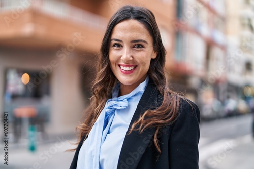 Young hispanic woman smiling confident standing at street