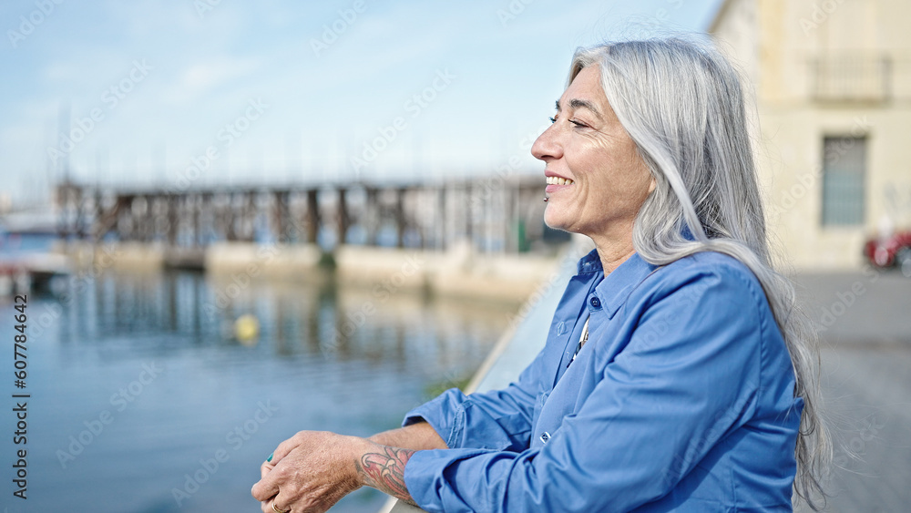 Fototapeta premium Middle age grey-haired woman smiling confident standing at seaside
