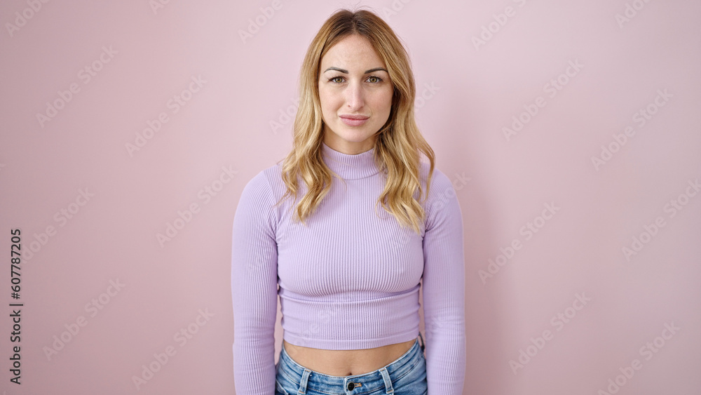 Obraz premium Young beautiful hispanic woman standing with serious expression over isolated pink background