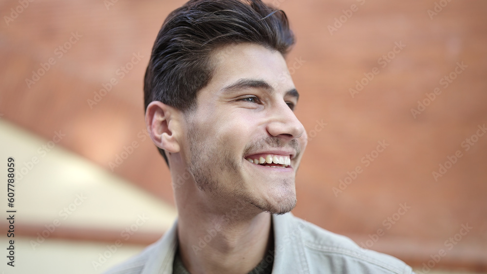 Young hispanic man smiling confident looking to the side at street Young hispanic man smiling confident looking to the side at street