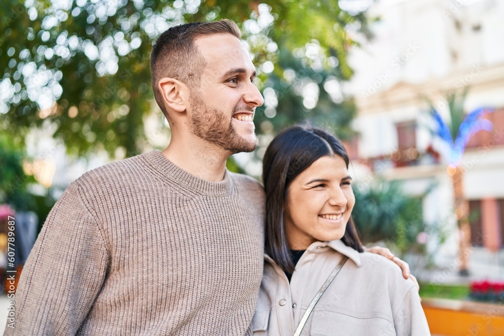 Fototapeta premium Man and woman couple smiling confident hugging each other standing at park