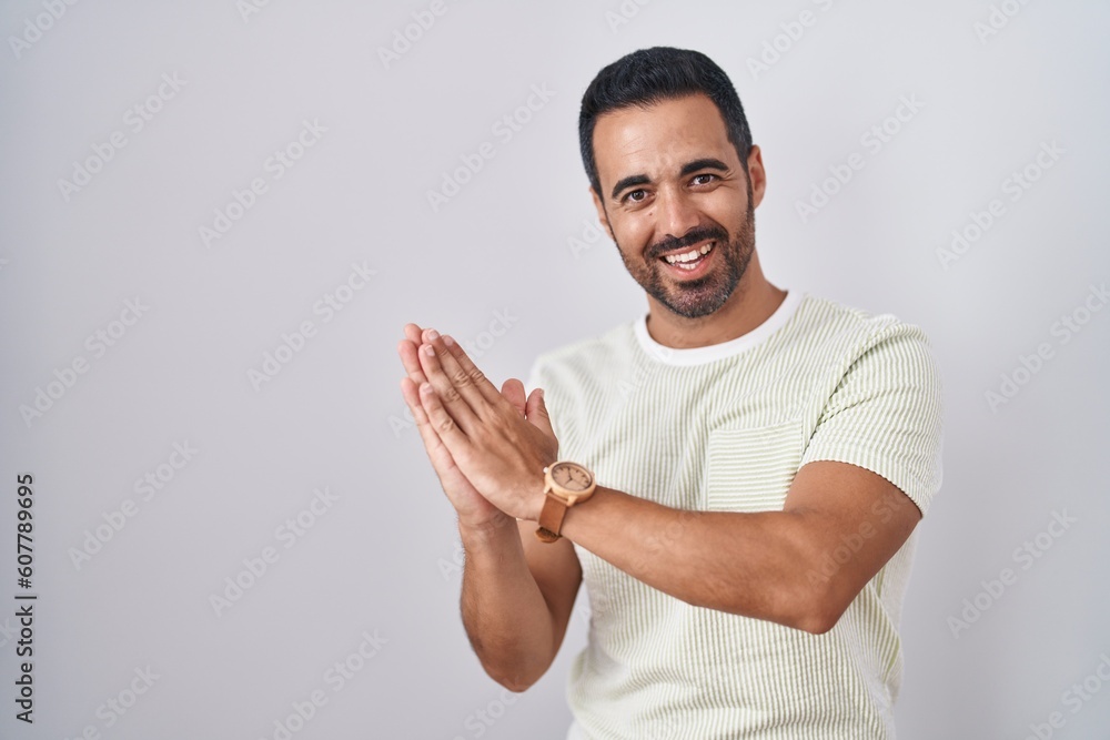 Hispanic man with beard standing over isolated background clapping and applauding happy and joyful, smiling proud hands together Hispanic man with beard standing over isolated background clapping and applauding happy and joyful, smiling proud hands together