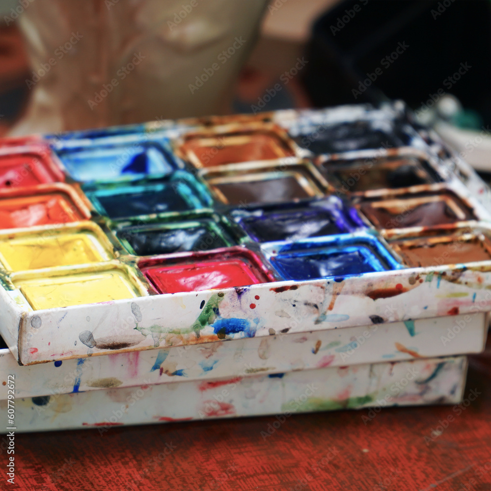 Watercolor paints on the table. Selective focus Watercolor paints on the table. Selective focus