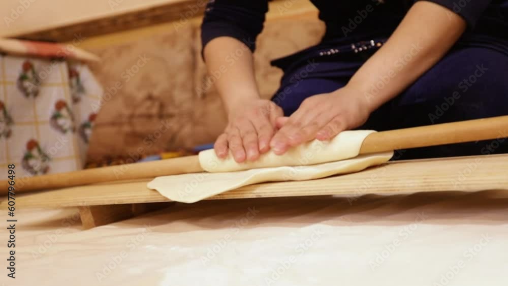The dough is rolled out with a rolling pin The dough is rolled out with a rolling pin