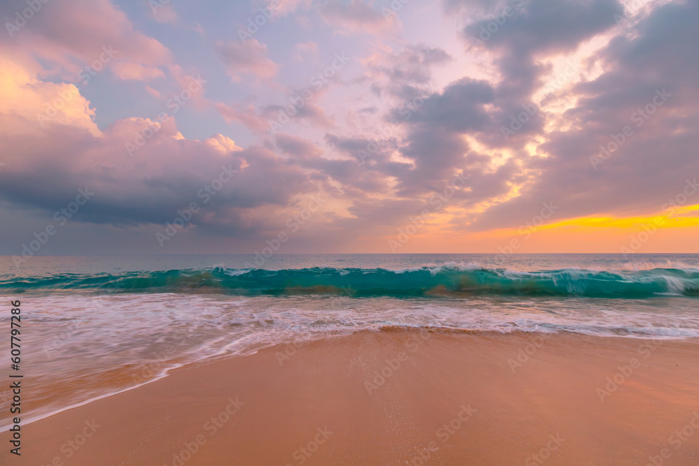 Waves on sandy ocean beach under a beautiful sunset sky with clouds on Sri Lanka island.