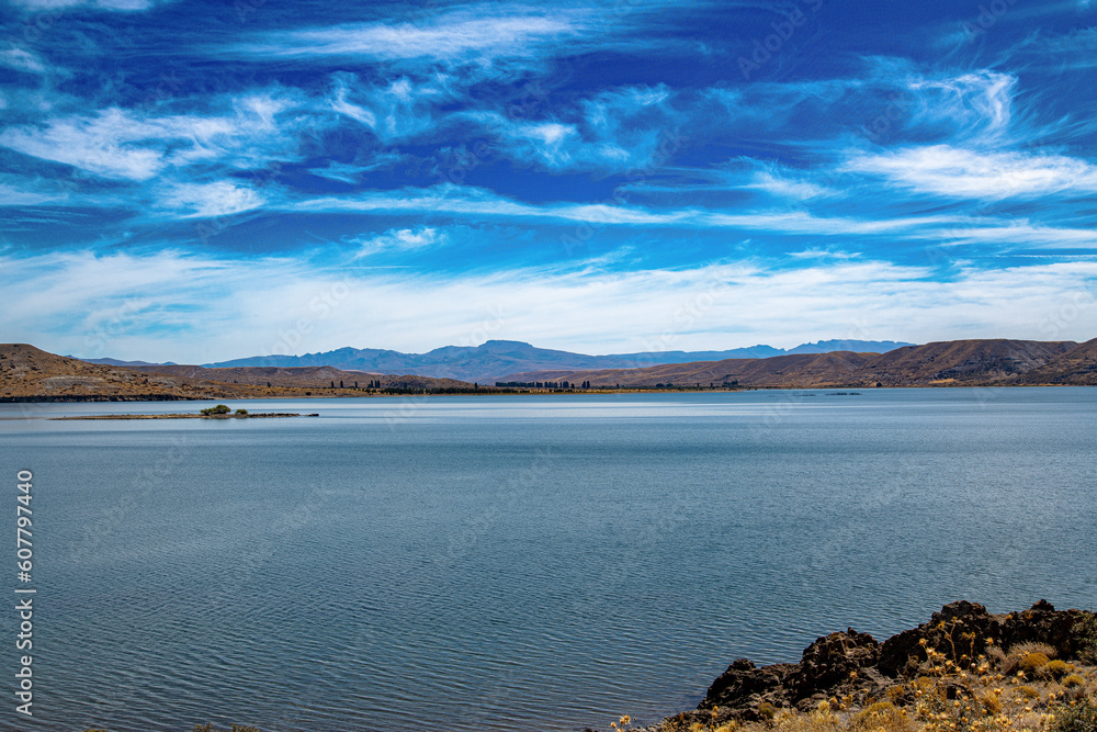 Fototapeta premium Experience the awe-inspiring beauty of Embalse Piedra de ?guila, where the tranquil reservoir harmonizes with the dramatic landscapes of Argentina