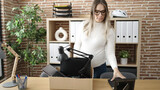 Young pregnant woman being fired packing belongings from workplace at office