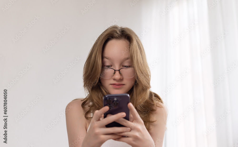 The girl looks indignantly at the smartphone. The girl looks indignantly at the smartphone.
