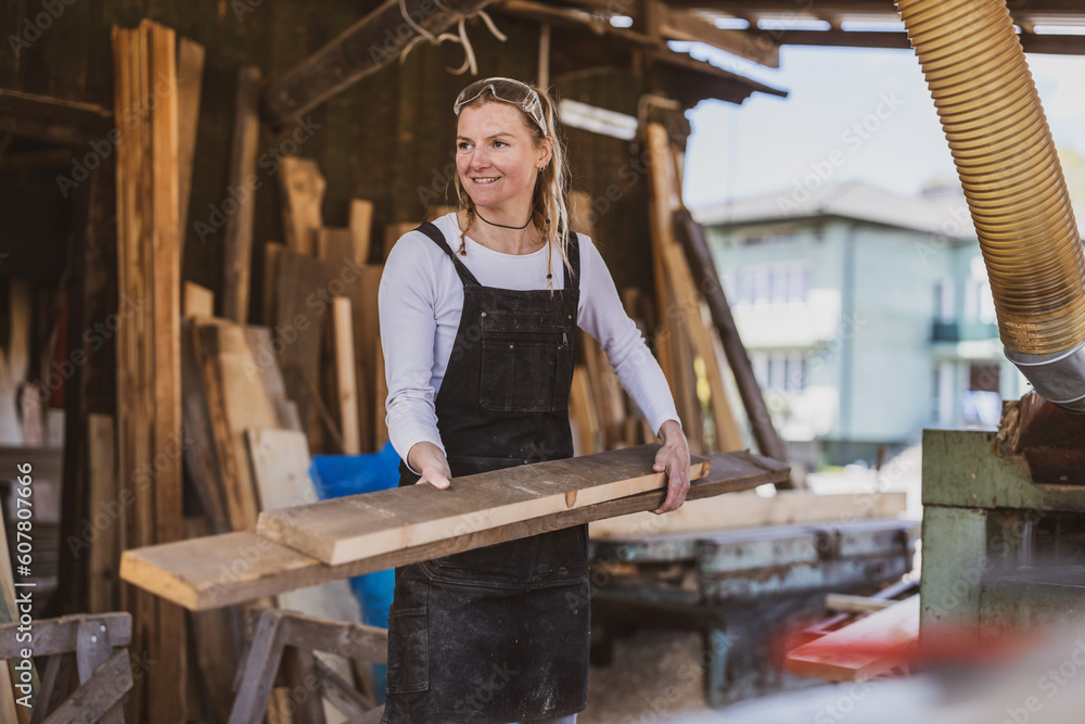 Woman working with wooden planks in a sawmill
Woman working with wooden planks in a sawmill