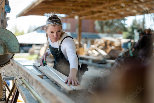 Woman working with wooden planks in a sawmill 