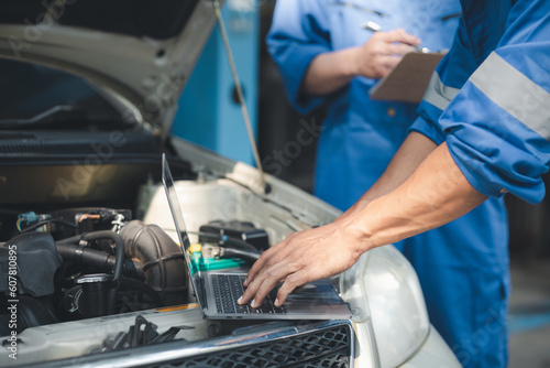 Two professional car mechanics are helping to inspect a customer\'s car being brought in for repair, all types of auto specialists, expert car repairs and certified auto repair centers.